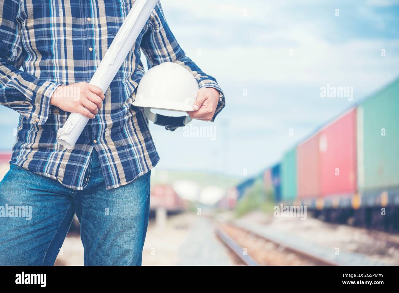 Bauingenieurteam mit Bauplan für das Projekt vor Ort, das in der Produktionsanlage für Eisenbahngleise arbeitet. Konzept Der Industrietechnik. Stockfoto