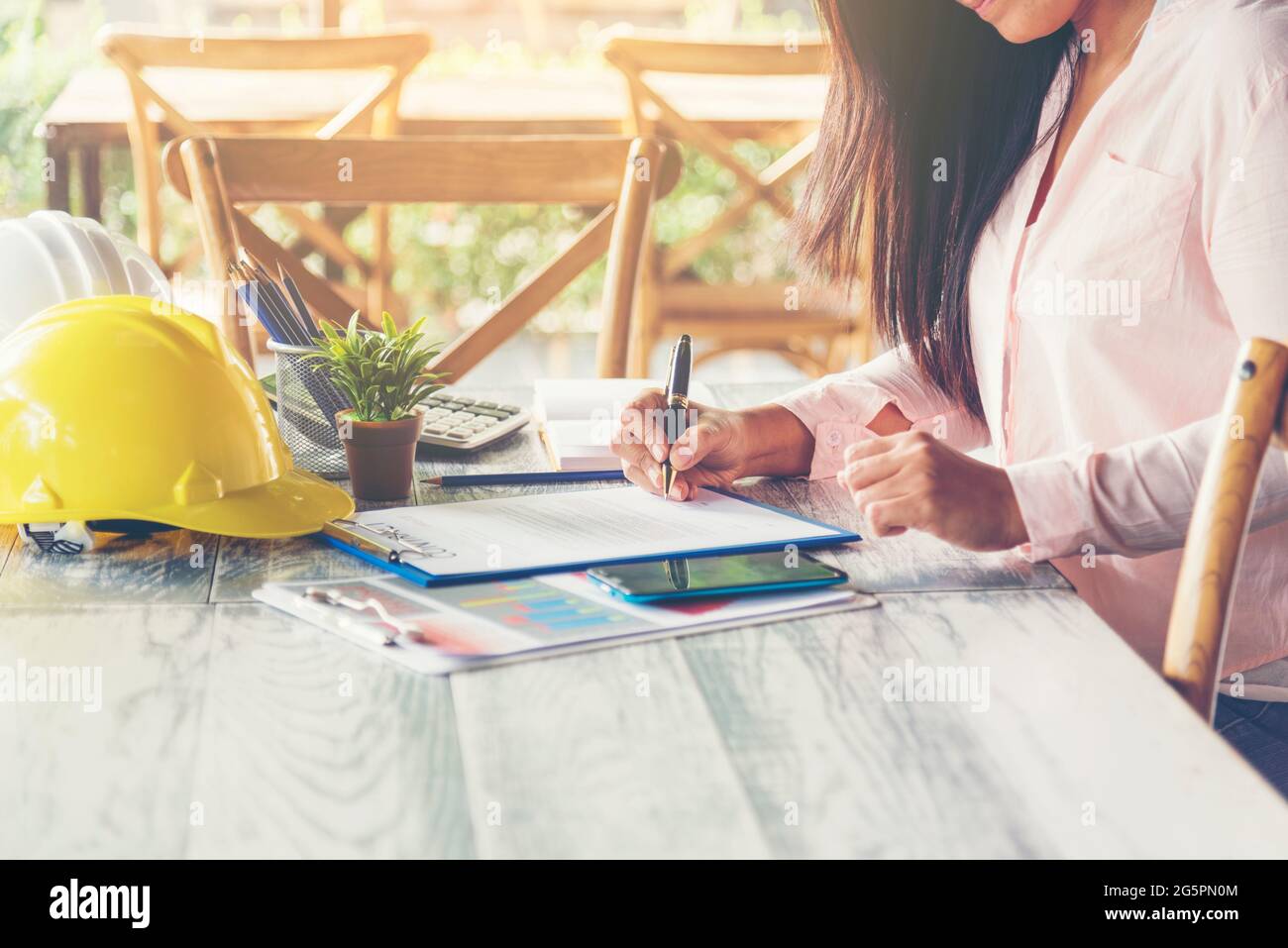Bauingenieurteam mit Bauplan für das Projekt vor Ort, das in der Produktionsanlage für Eisenbahngleise arbeitet. Konzept Der Industrietechnik. Stockfoto