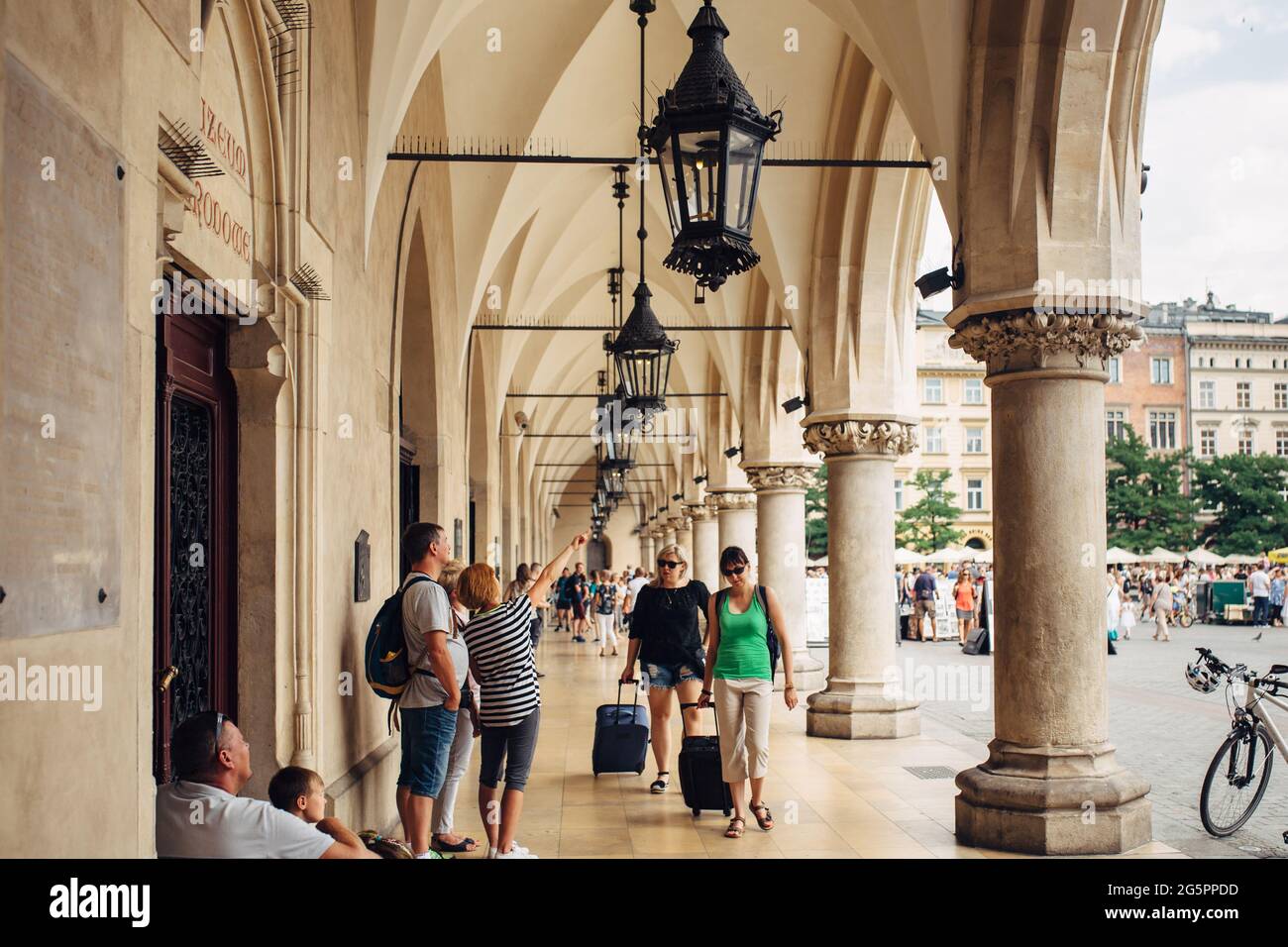 KRAKAU, POLEN - 21. Juli 2019: Tucheinkaufshalle (Sukennice) am Hauptplatz mit Touristen, die durch die Stadt laufen. Altstadt von Krakau, beliebte Reisedesti Stockfoto