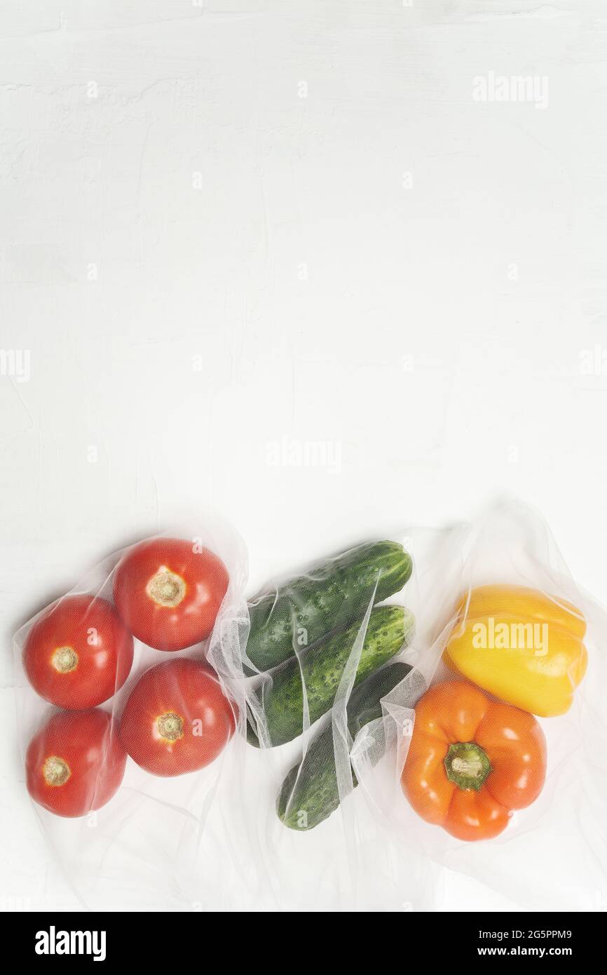 Wiederverwendbare Beutel mit, frisches Gemüse Tomaten, Gurken, Paprika auf weißem Hintergrund, Zero Waste Konzept Stockfoto