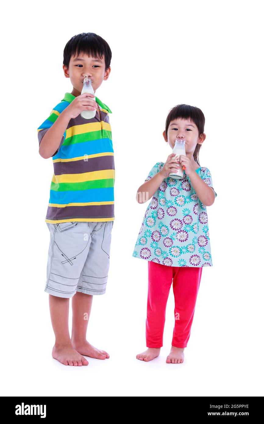 Lustige Porträt von Kindern mit einer Flasche Milch. Milch trinken für eine gute Gesundheit. Zwei asiatische Jungen und Mädchen, die Milch trinken, auf weißem Hintergrund. Studio Shoo Stockfoto