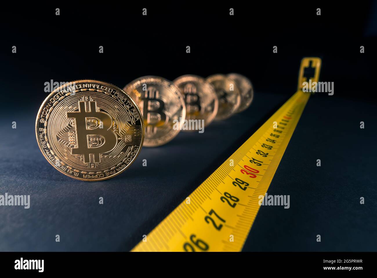 Konzept für Bitcoin-Krise, Preisschwankungen, Bitcoin-Preis sinkt auf 30 Tausend Dollar. Goldene Bitcoins mit einem Maßband daneben w Stockfoto