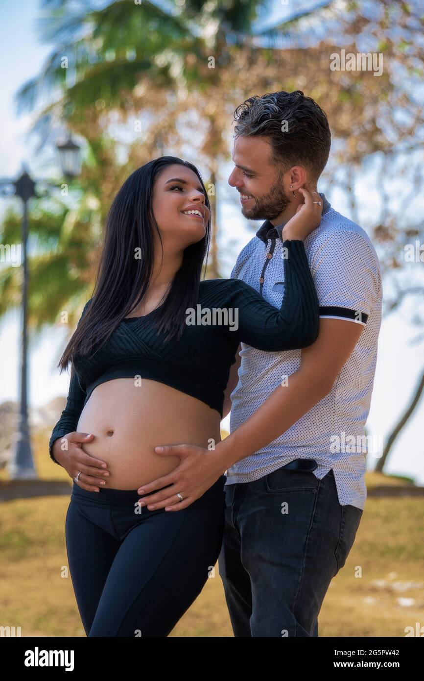 Foto eines jungen Paares mit den Händen auf dem Bauch der Schwangeren Stockfoto