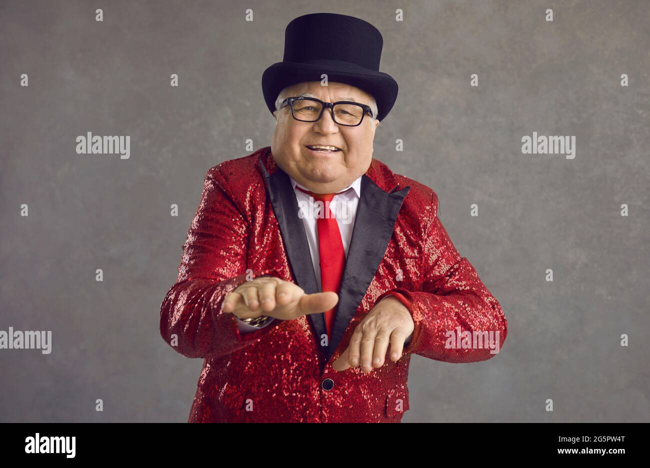 Witziger, fetter Senior in einer roten Paillettenjacke, der sich auf einer verrückten Retro-Disco-Party amüsieren kann Stockfoto