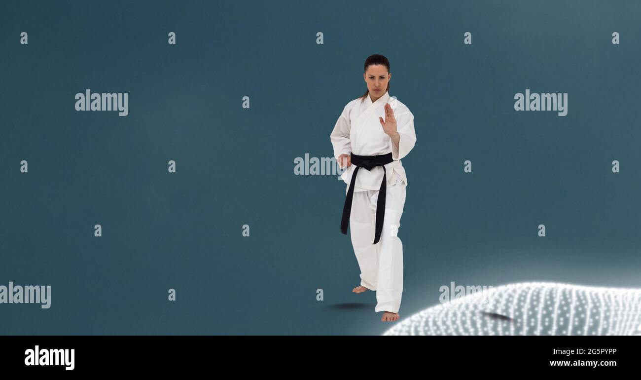 Kaukasische Kampfkünstlerin mit schwarzem Gürtel gegen digitale Wellen auf grünem Hintergrund Stockfoto
