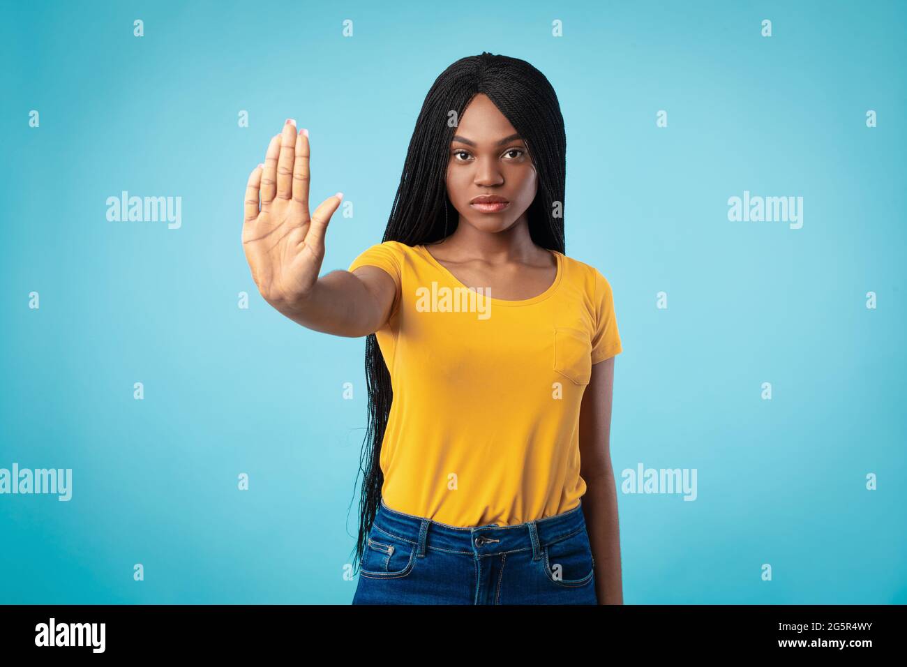 Entschlossene Afroamerikanische Frau Gestikuliert Stop To Camera, Blauer Hintergrund Stockfoto