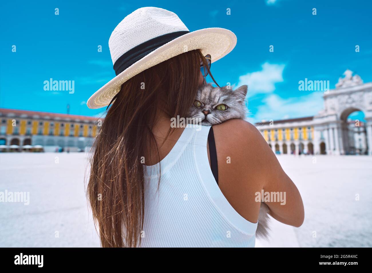 Frau umarmt ihre schöne flauschige Katze. Reisen Sie mit einem Haustier. Frau, die Lissabon mit ihrer Katze erkundet. Commerce Square Stockfoto