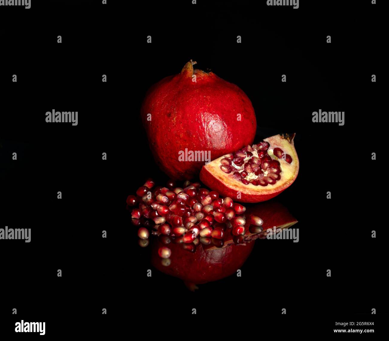 Saftig roter Granatapfel auf dunklem Grund Stockfoto