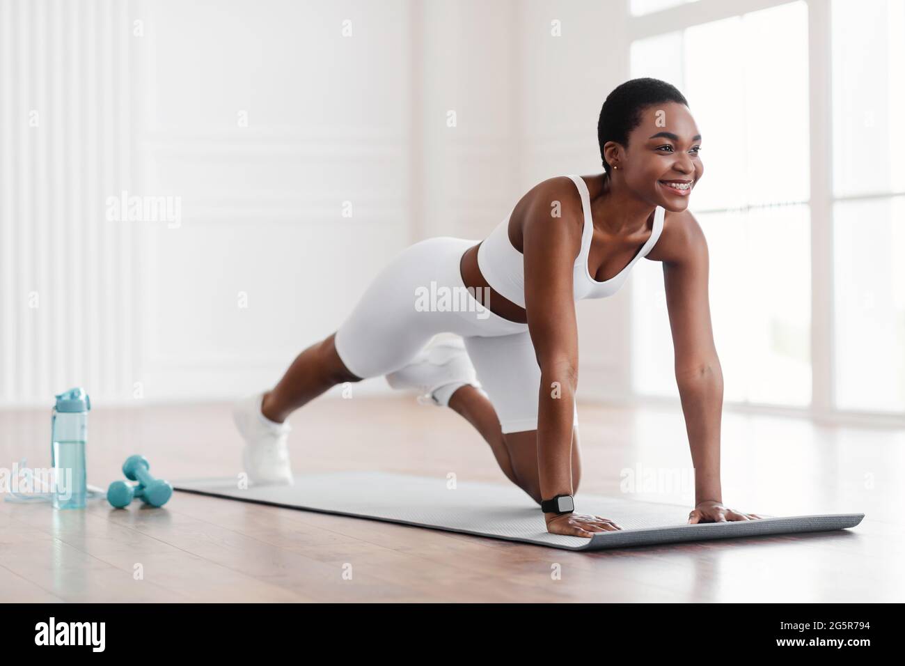 Afro-Fröhliche Frau, Die Die Übung Von Cross Body Mountain Kletterern Macht Stockfoto