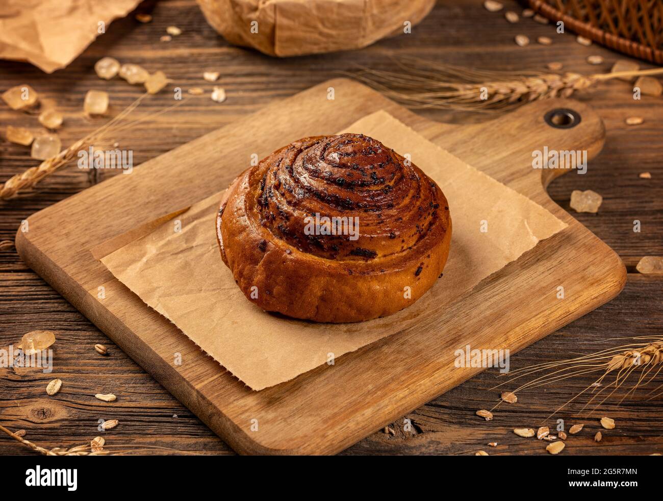 Süße Brötchen mit Mohnsamen, süßes Brötchen auf rustikalem Holzhintergrund Stockfoto