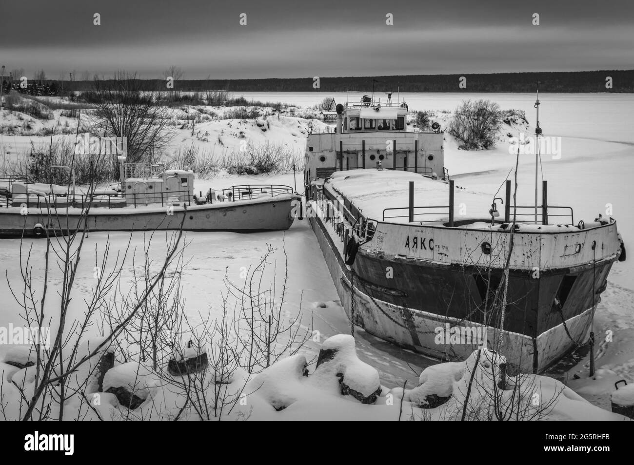 Verlassene Seeschiffe am Ufer im Winter. Naberezhnye Chelny, Russland. Schwarz und Weiß. Stockfoto