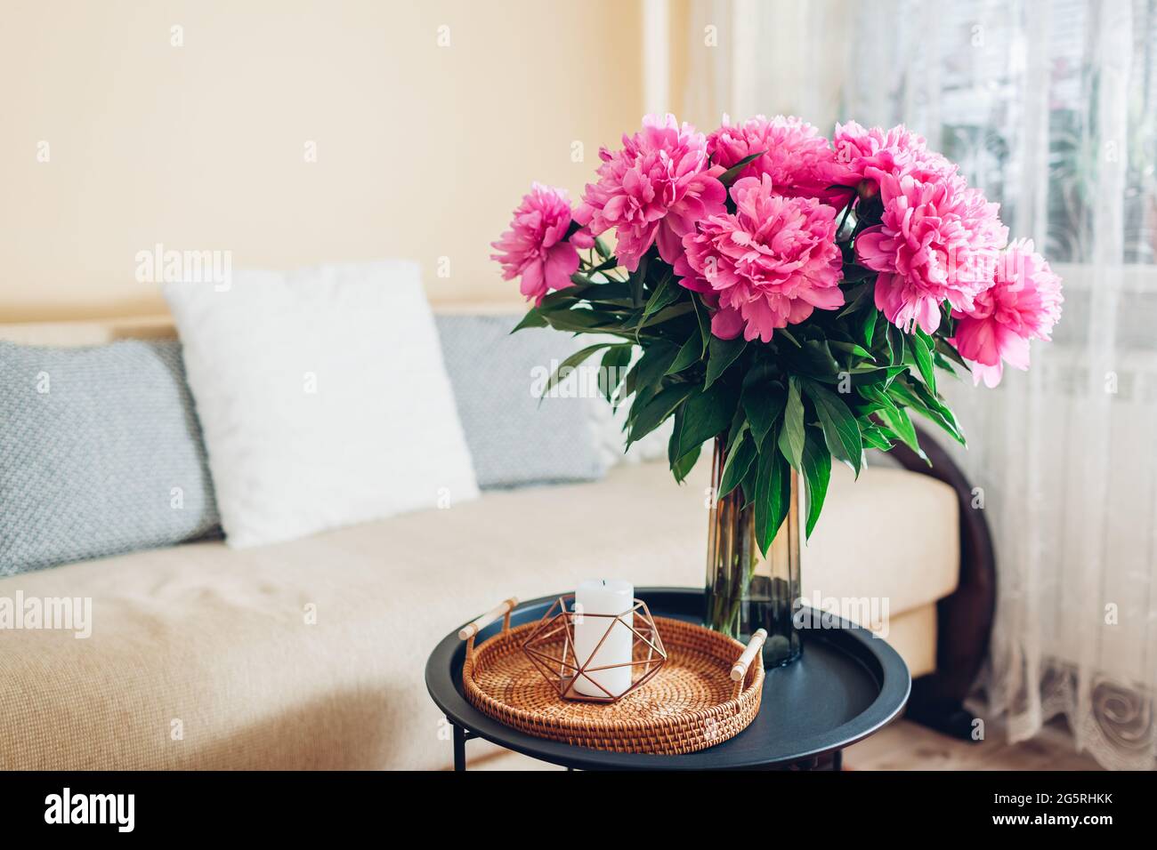 Inneneinrichtung und Inneneinrichtung. Frische rosa Pfingstrosen Blumen in Vase im Wohnzimmer gelegt. Blumenstrauß auf dem Couchtisch Stockfoto