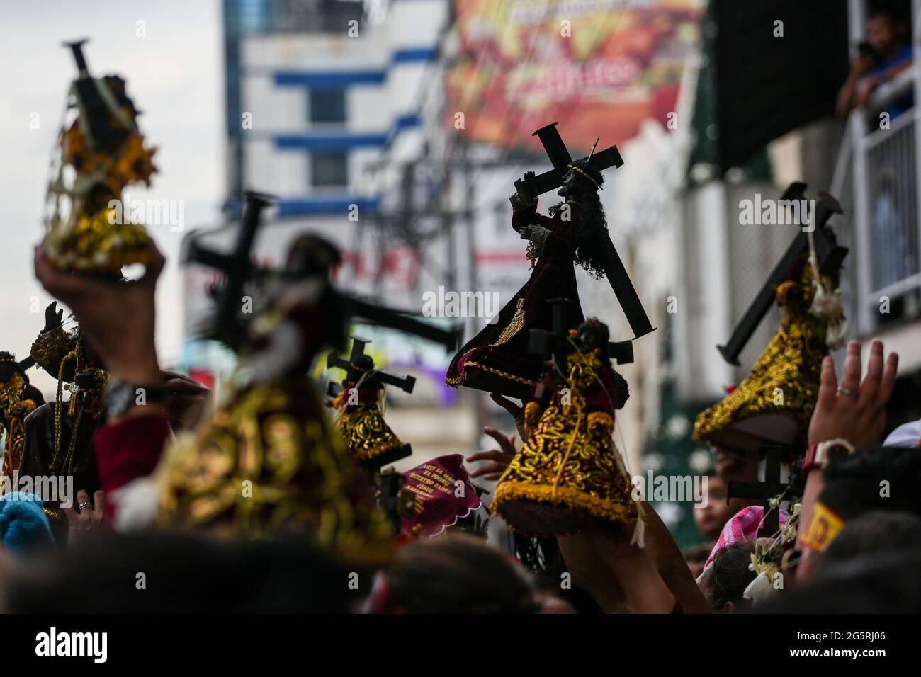 Philippinisch-katholische Anhänger heben vor dem Fest des Schwarzen Nazareners in Manila, Philippinen, Miniaturnachbildungen von Black Nazarene an. Stockfoto