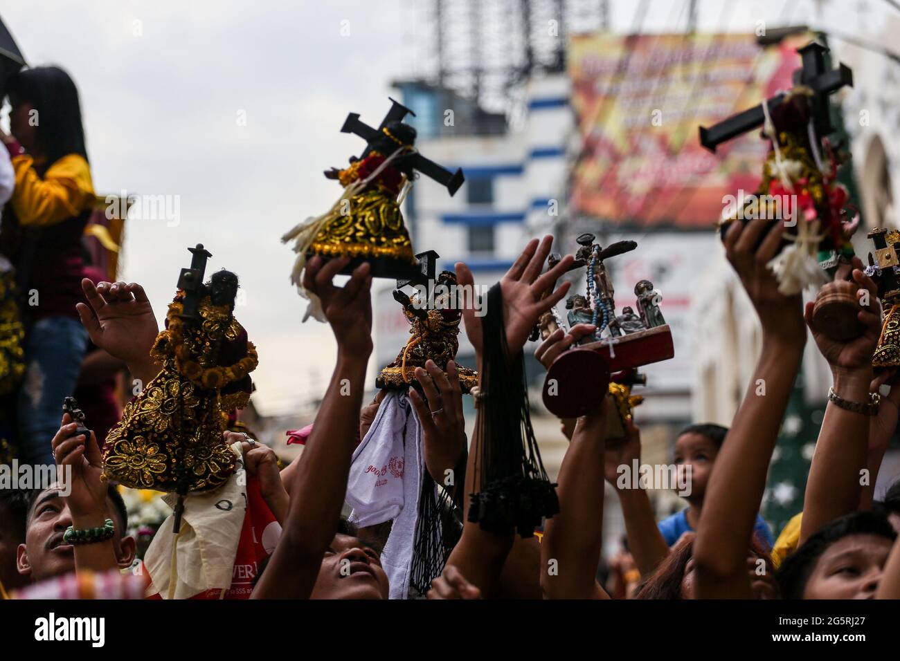 Philippinische katholische Anhänger tragen ihre Miniaturnachbildungen des Schwarzen Nazareners während der Segnung der Nachbildungen vor dem Fest des Schwarzen Nazareners in Manila, Philippinen. Stockfoto