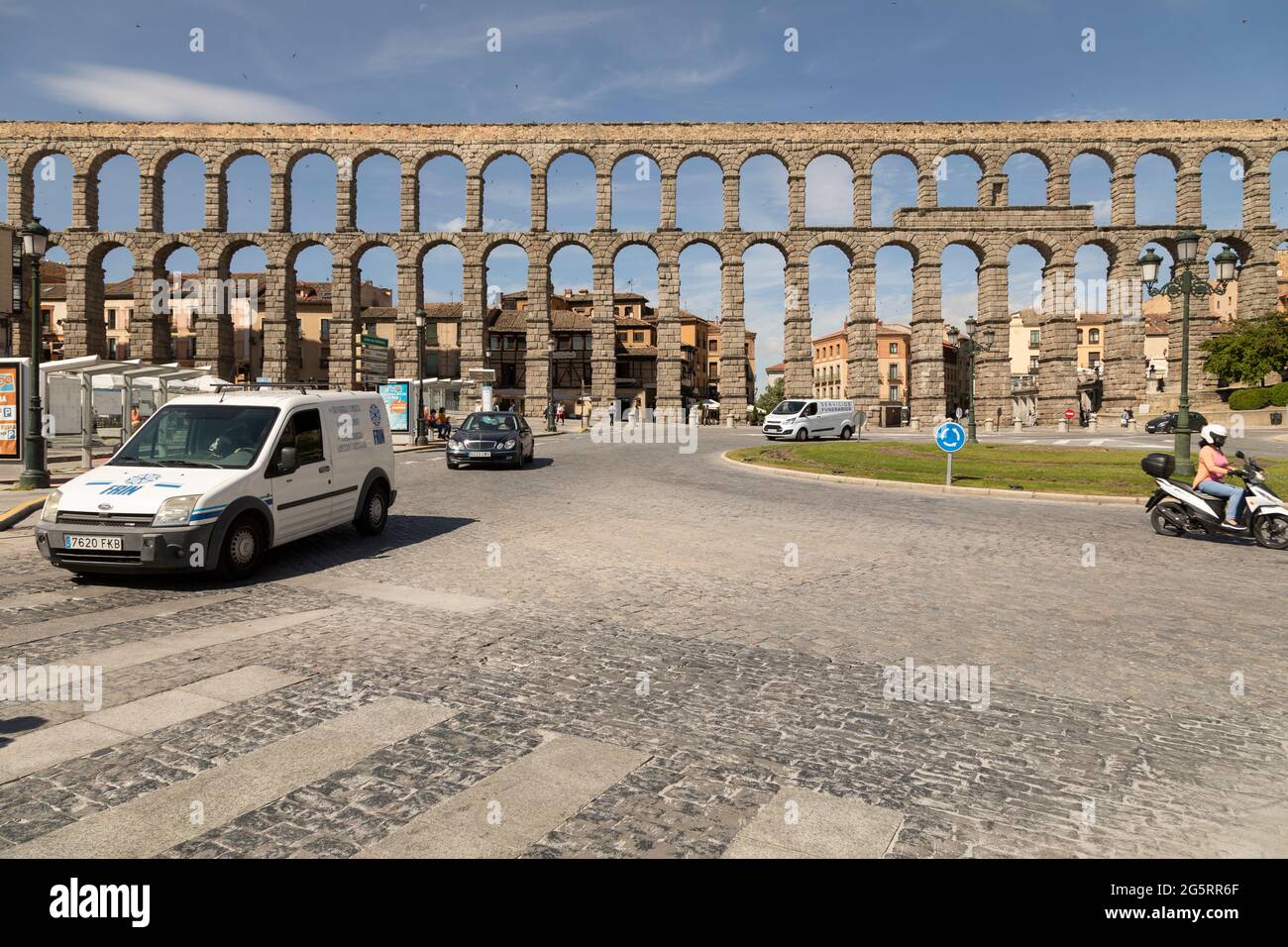 Segovia, Spanien - 2. Juni 2021: Allgemeine Ansicht des Aquädukts von Segovia, an einem sonnigen Tag, und der Kreisverkehr für den Verkehr neben der Plaza del Azoguejo Stockfoto