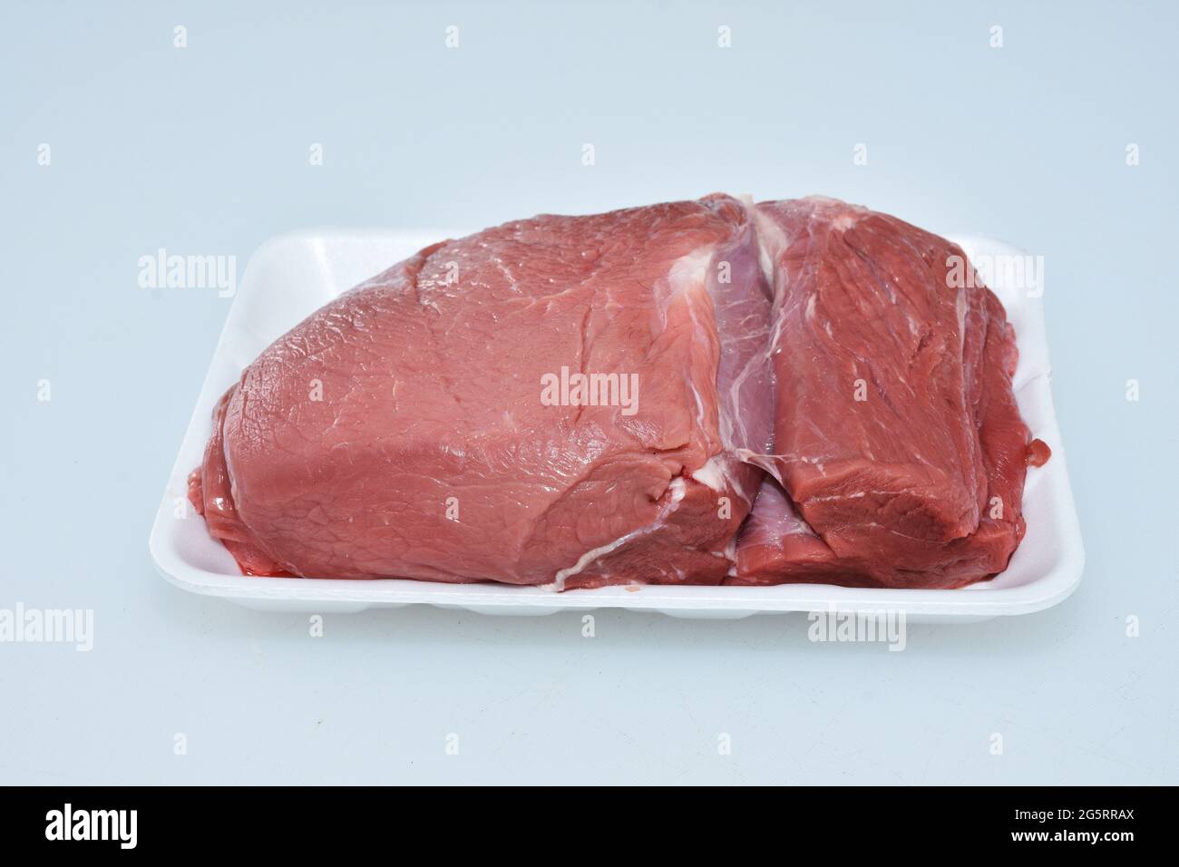 Lamm dicke Flanke ohne Knochen Fleisch in Teller auf weißem Hintergrund, Metzgerschnitt, rohes Hammelstück Stockfoto