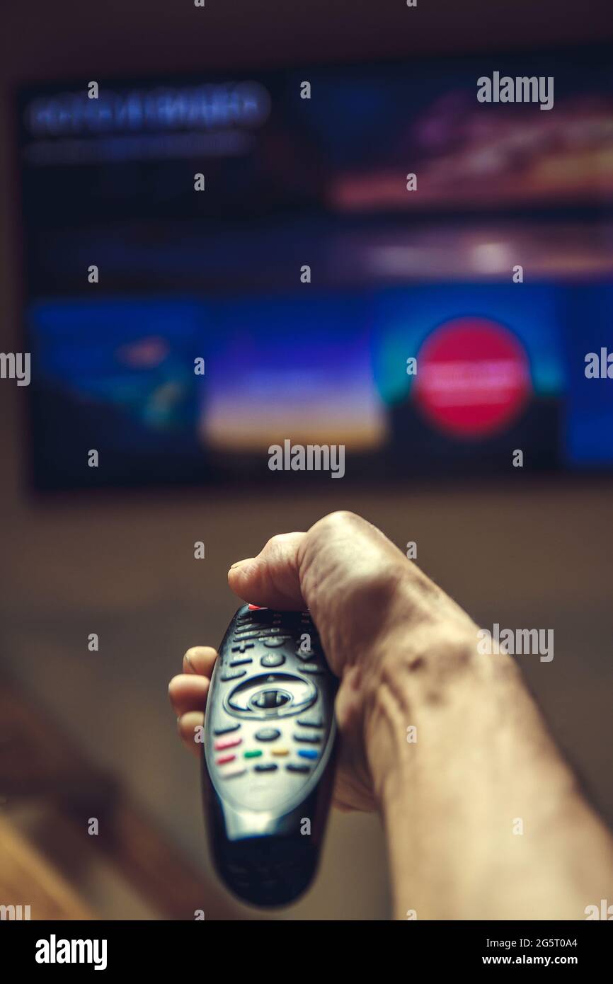 Männliche Hand, die TV-Fernbedienung. Stockfoto