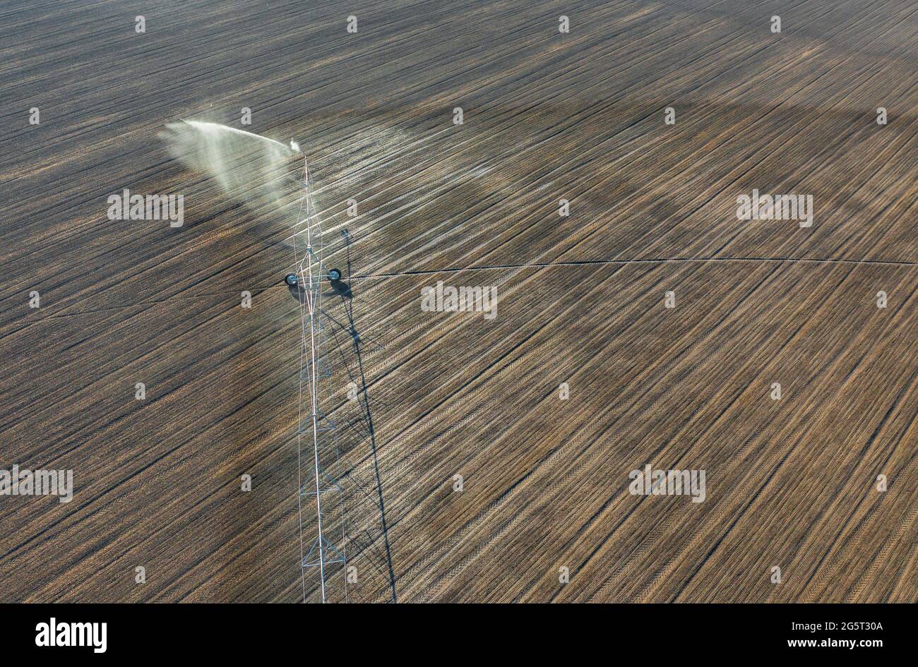 Luftaufnahme über das zentrale Schwenk-Bewässerungssystem, das Kulturen sprüht. Farm-Konzept, moderne Bewässerungsausrüstung, Landwirtschaft Textur. Stockfoto