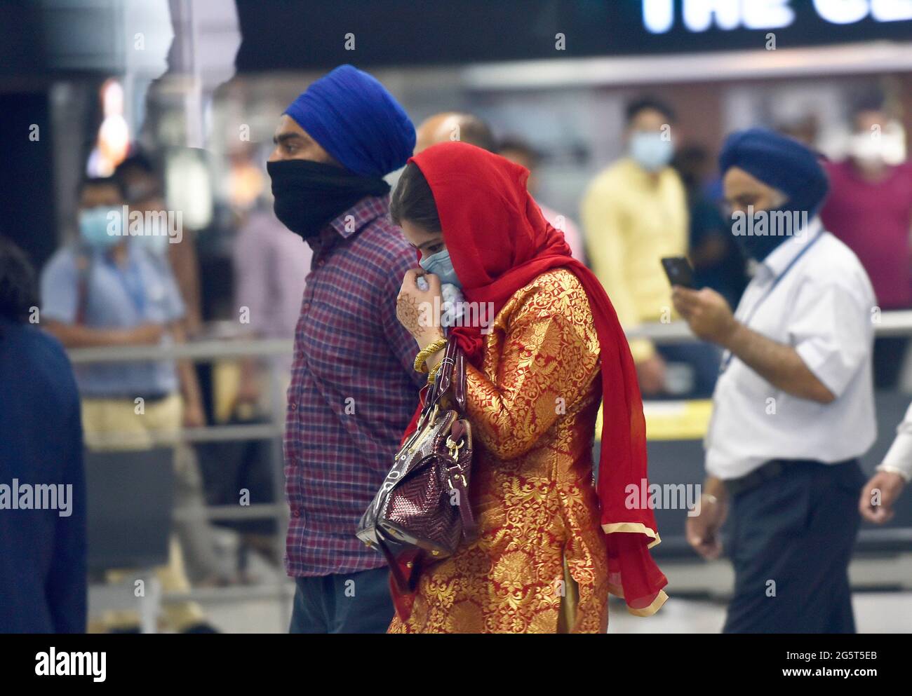 NEW DELHI, INDIEN - 29. JUNI: Die Sikh-Frau Manmeet Kaur kommt mit ihrer Familie am IGI-Flughafen T3 von Srinagar an, nachdem sie behauptet hatte, eine einversetzliche religiöse Bekehrung zu haben, am 29. Juni 2021 in Neu-Delhi, Indien. Nach den Protesten von Sikh-Gruppen in Jammu und Kaschmir, die behaupteten, dass zwei Frauen in Srinagar ‘entführt, konvertiert und verheiratet' wurden, wurde eine der 26-jährigen Frauen Manmeet Kaur, eine aus Srinagar wohnende, am Samstagabend ihrer Familie übergeben und in ihrer Gemeinde verheiratet. (Foto von Sanjeev Verma/Hindustan Times/Sipa USA) Stockfoto