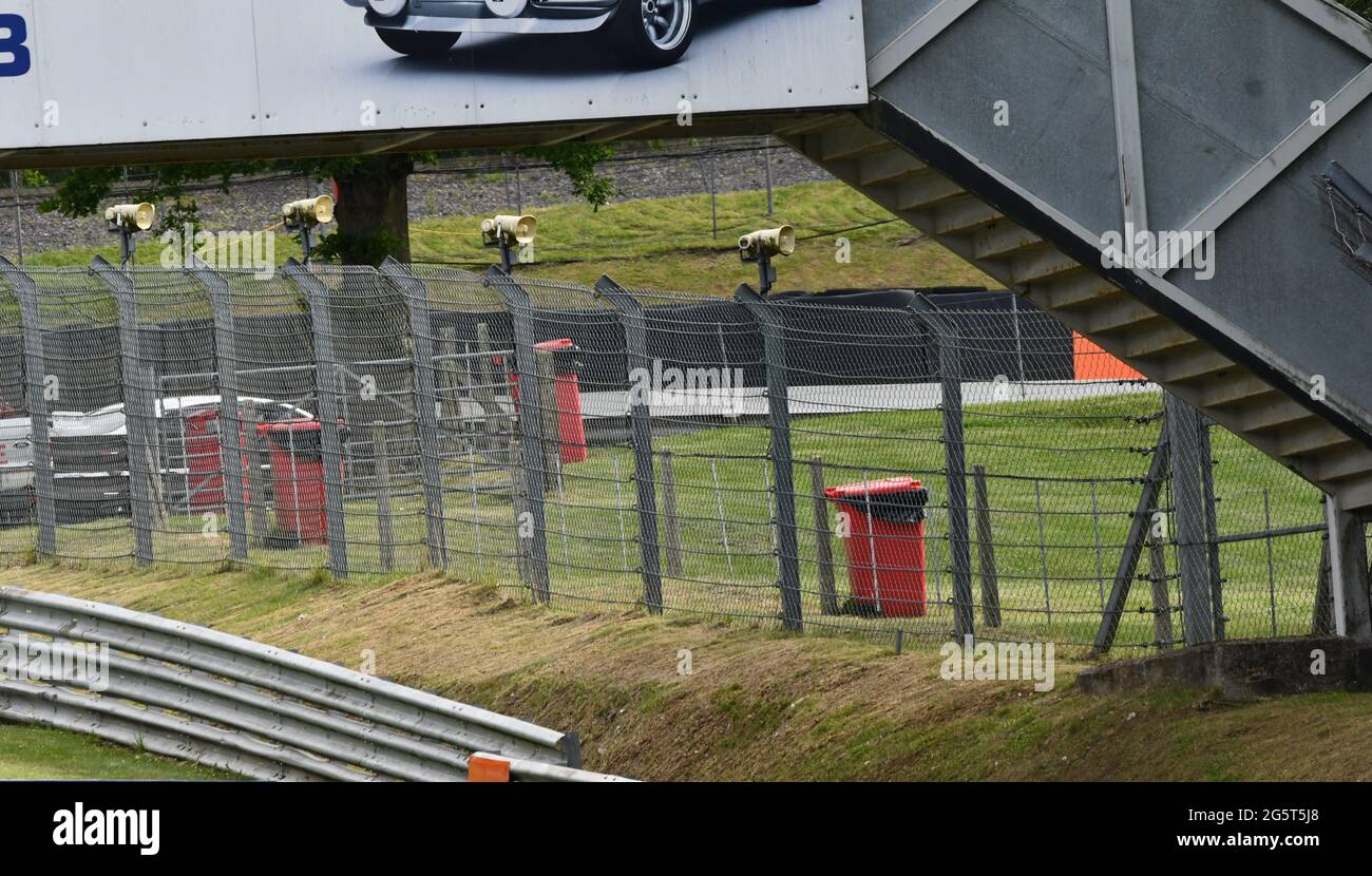 Die Sicherheitsbarrieren, die Sicherheitszauntreppen über die Strecke und die Beschallungslautsprecher Stockfoto