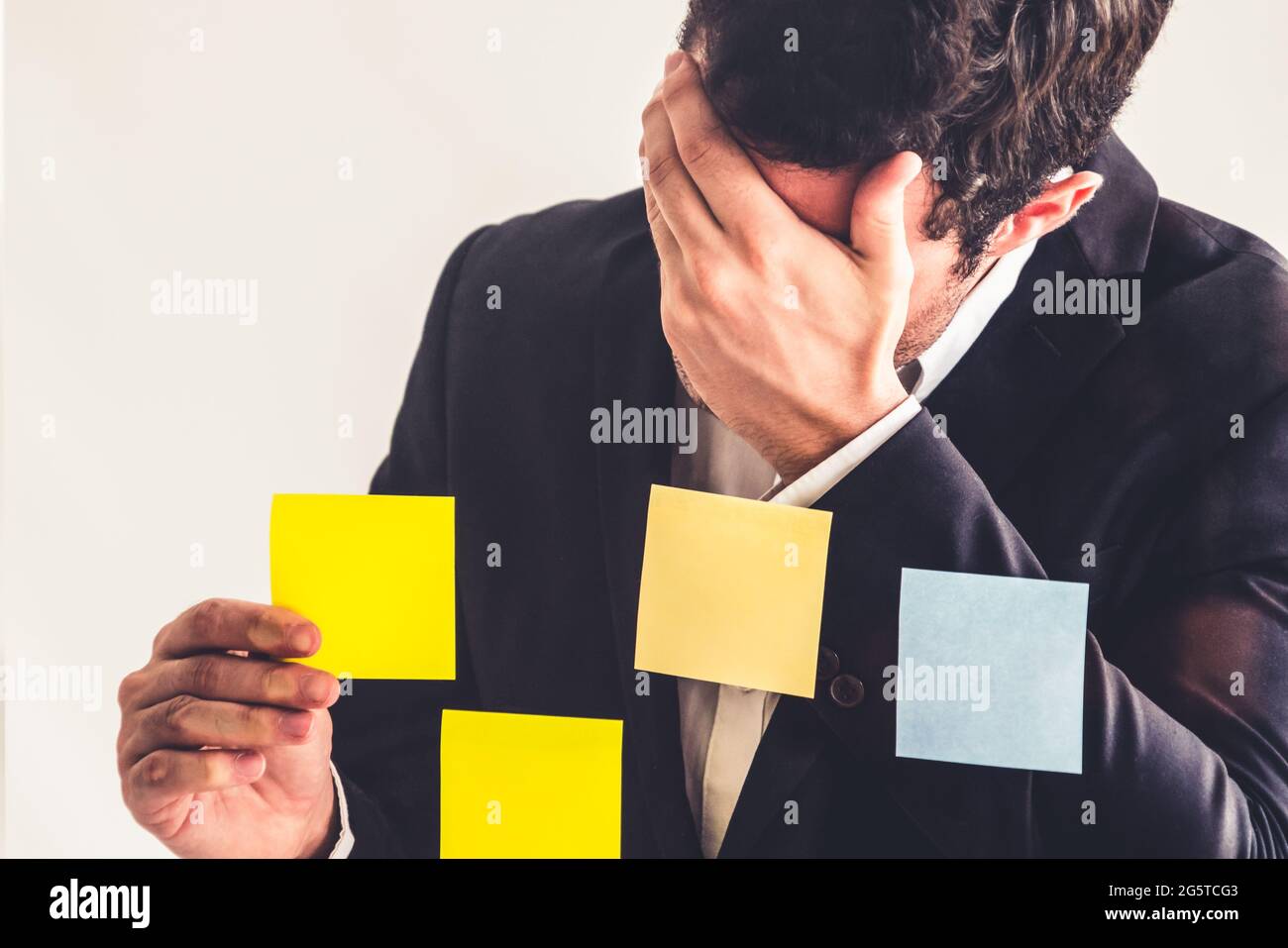 Ernsthafte Geschäftsmann fühlt sich enttäuscht und Haftnotiz auf die Fenster im Büro. Konkurs und Ausfall Konzept. Stockfoto