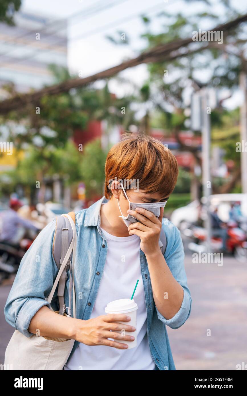 Der Reisende trägt eine Einweg-Gesichtsmaske zum Schutz vor Infektionen. Stockfoto