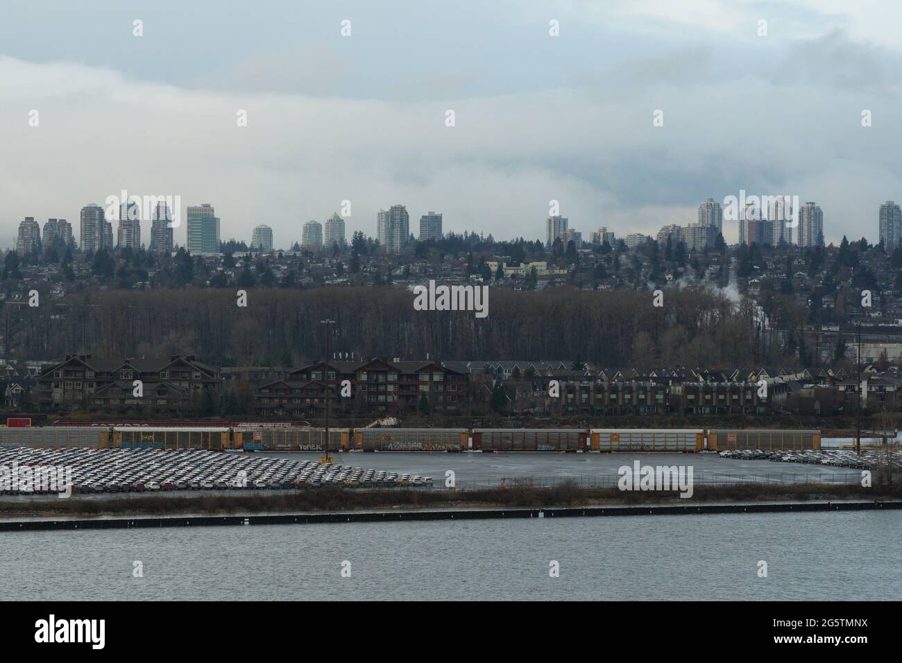 Blick auf geparkte Neuwagen und Güterzug vom Schiffscontainer-Terminal in Vancouver, Kanada. Stockfoto