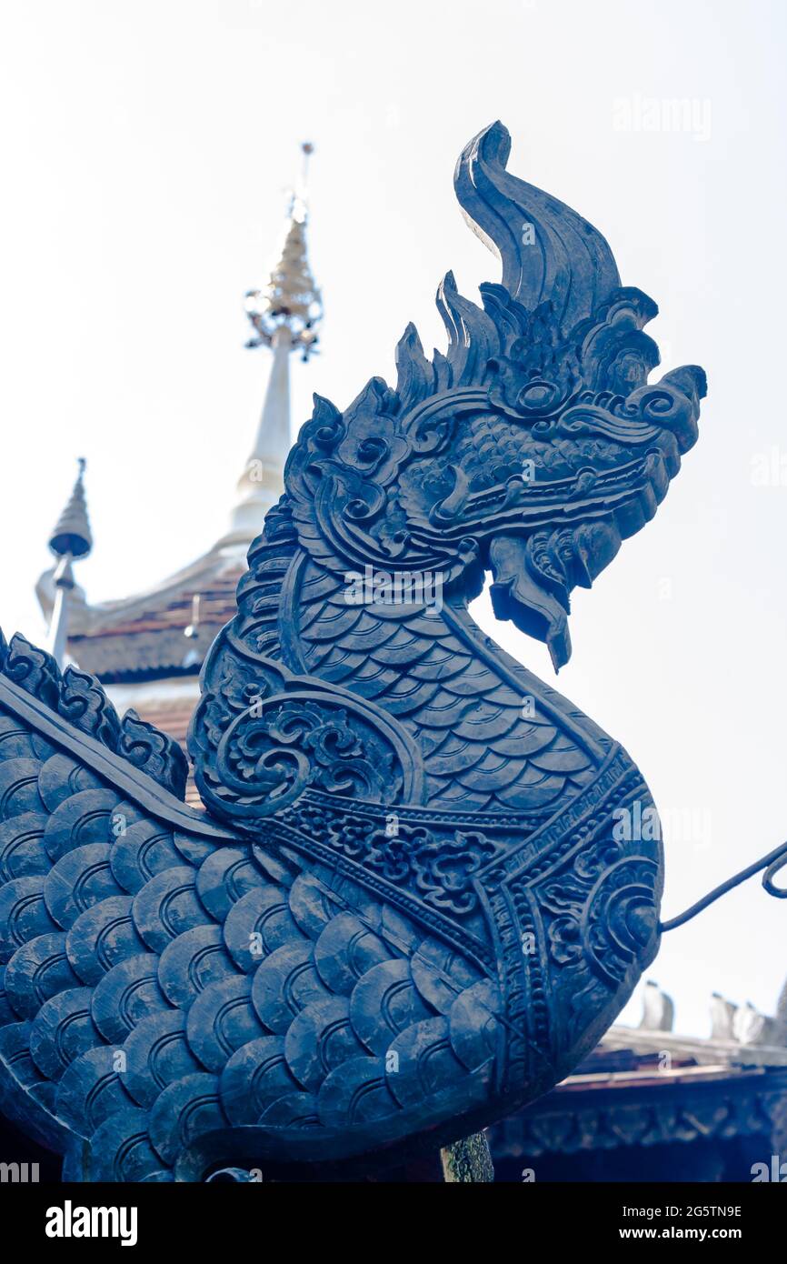 Der Kopf einer geschnitzten schwarzen Holzschlange wurde verwendet, um das Dach eines Tempels im Norden Thailands zu schmücken. Stockfoto