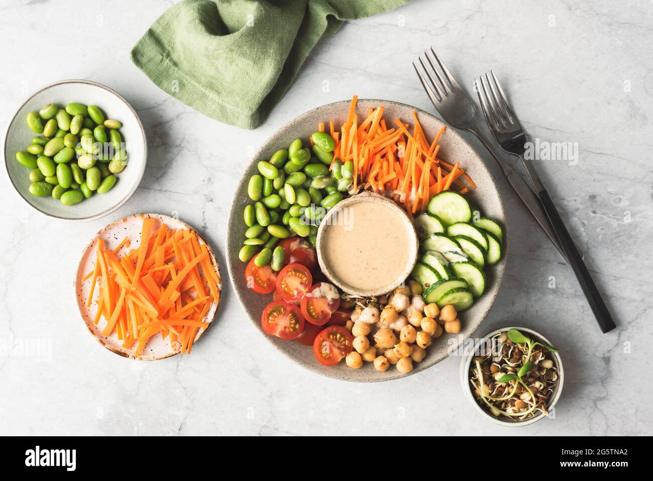 Gesunde vegane buddha Schale mit Kichererbsen, Hummus, Bohnen und Gemüse auf betontem Hintergrund, Draufsicht. Ausgewogene Mahlzeit Stockfoto
