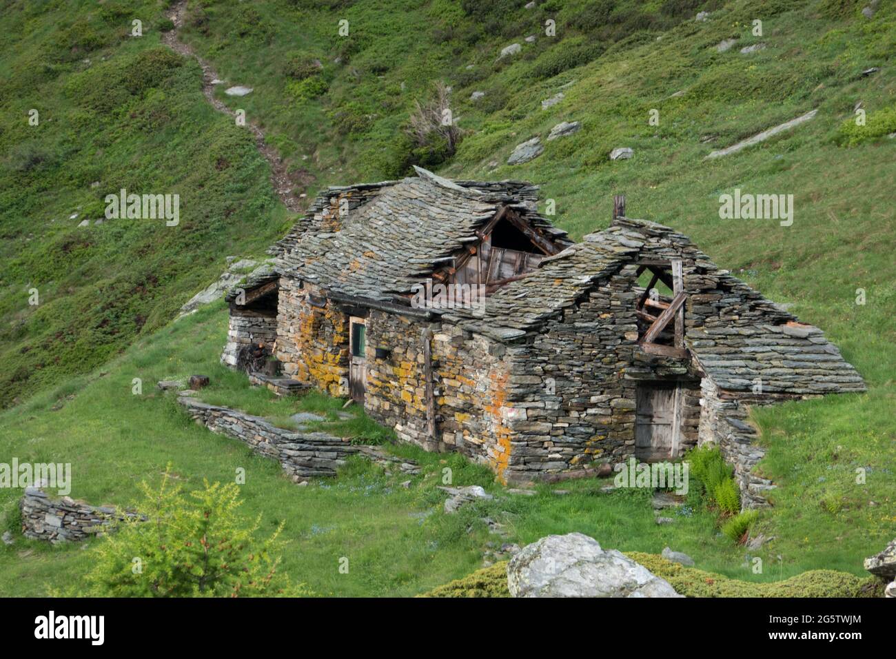 Heruntergekommenes traditionelles Bauernhaus in den italienischen Alpen Stockfoto