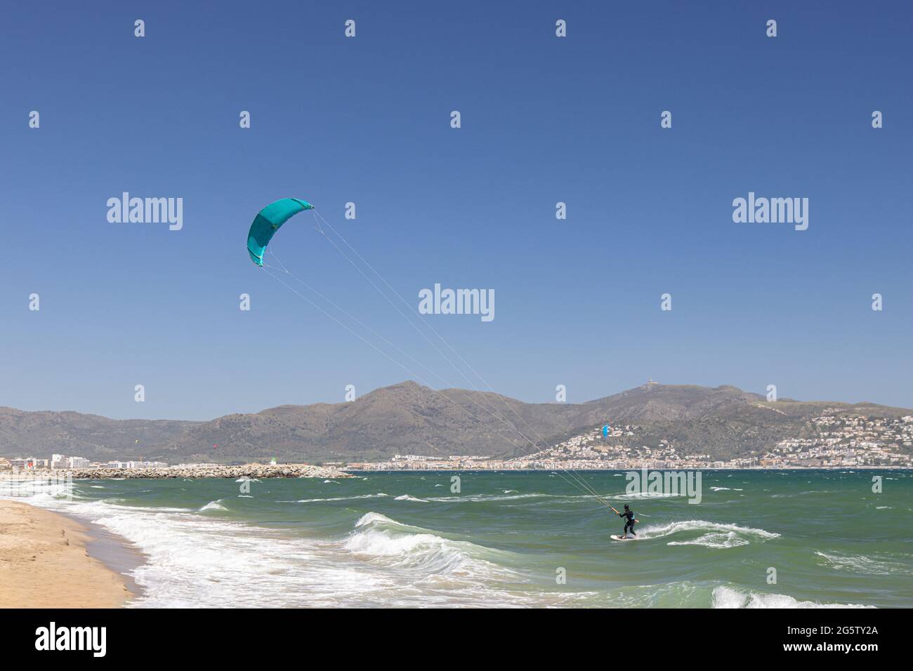 In Empuriabrava, Costa Brava, Provinz Girona, Katalonien, Spanien, wird ein Kiteboarder bei starkem Onshore-Wind von einem Starkdrachen über das Wasser gezogen. Kiteb Stockfoto