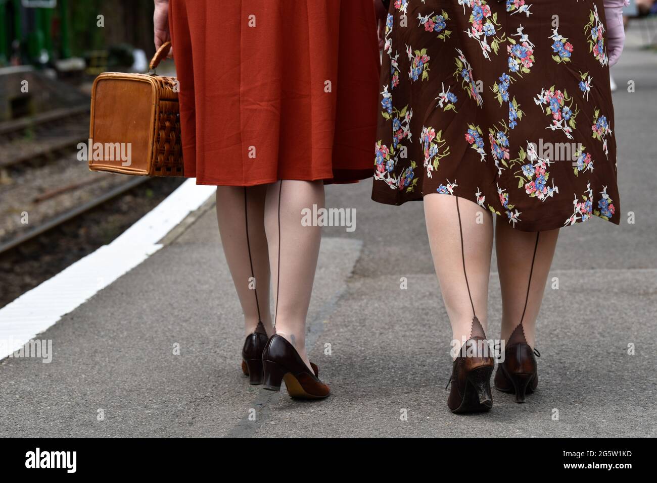 Zwei Frauen in den 1940er Jahren kleiden sich während des jährlichen „war on the Line“-Events in Alresford, Hampshire, Großbritannien, am Bahnhofsplatz entlang. Stockfoto