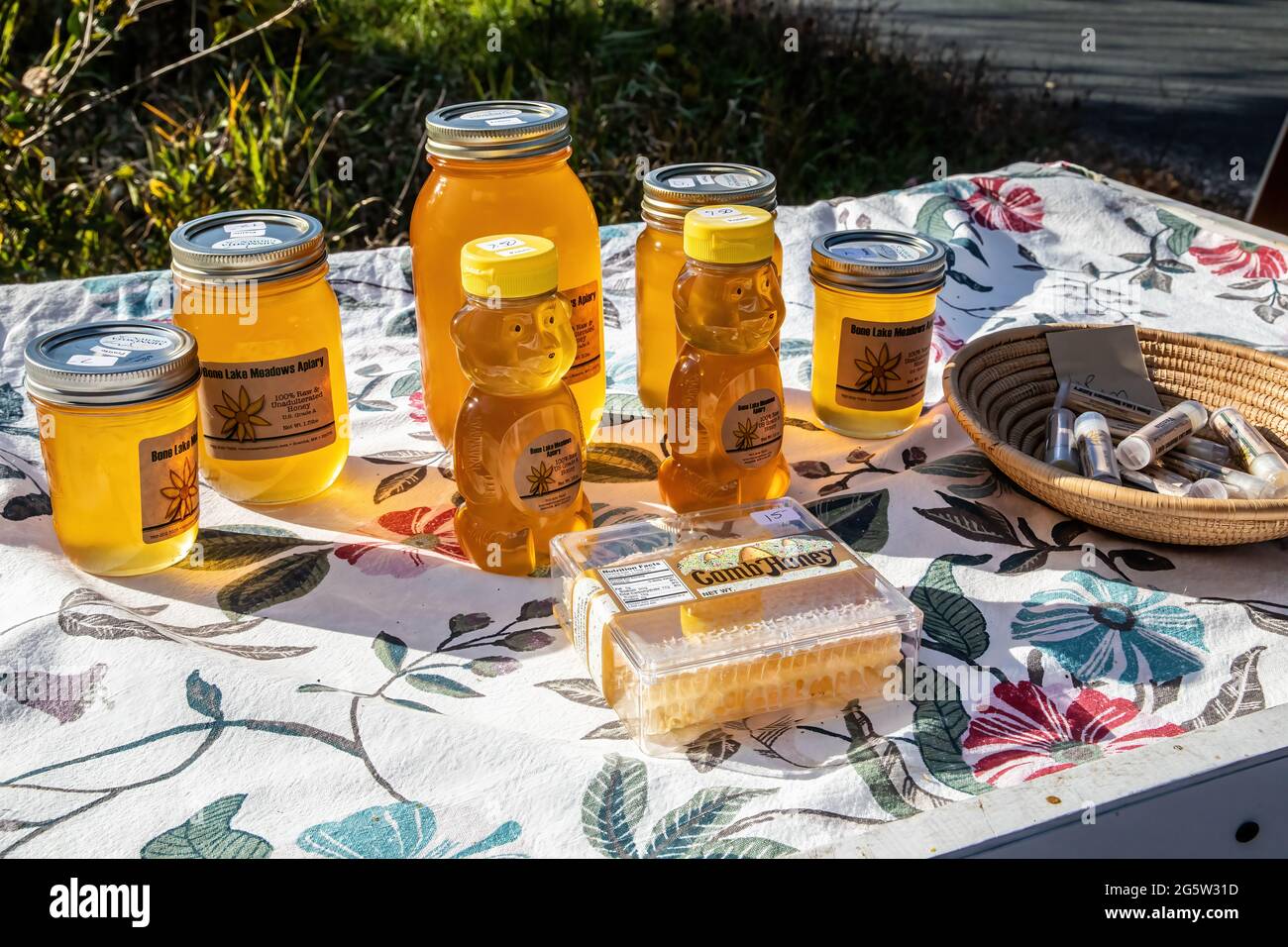 Honig, Wabenhonig und Lippenbalsam zum Verkauf von einem Straßenrand; Bone Lake Meadows Apiary. Stockfoto