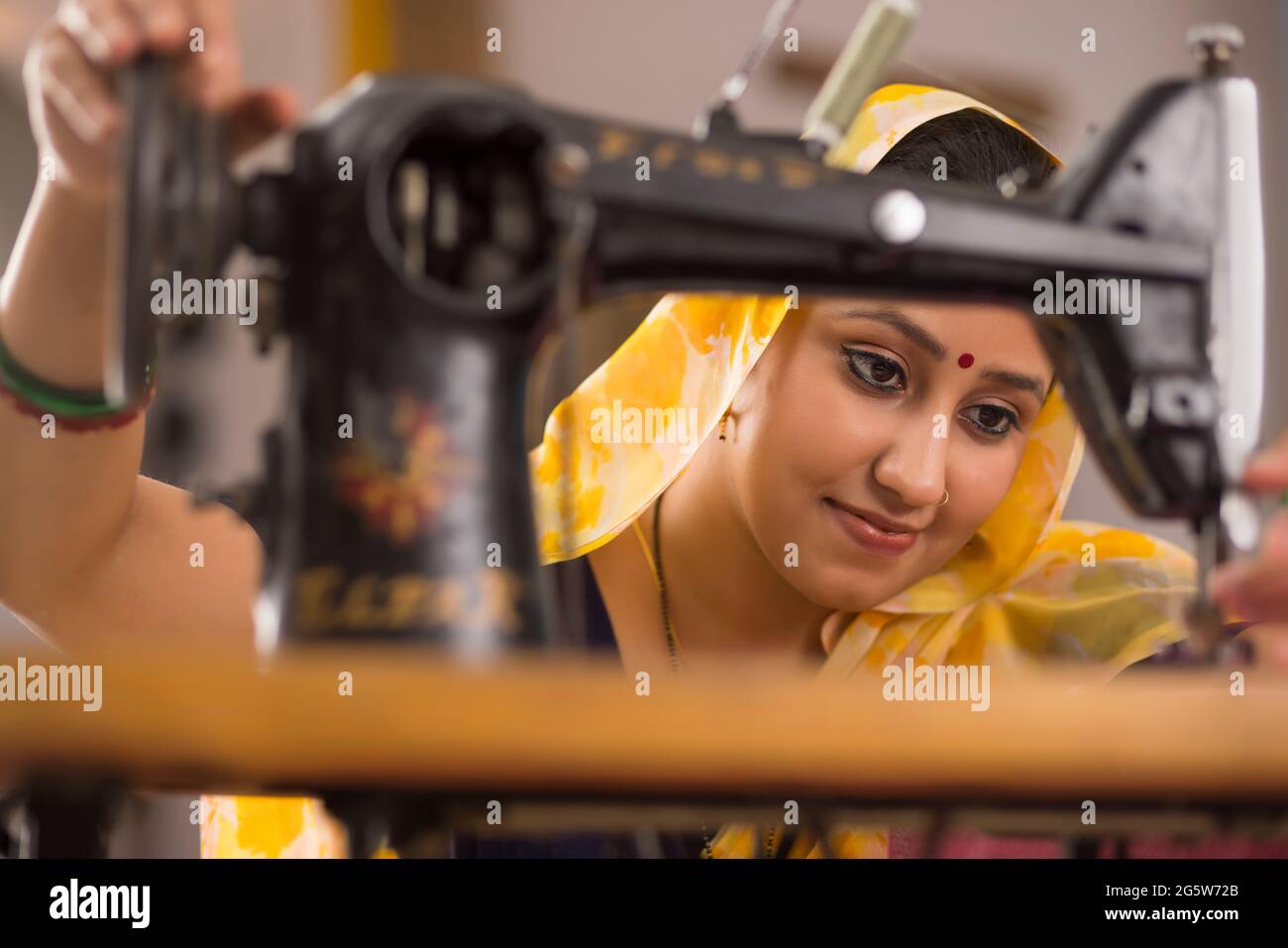 Eine Frau, die mit einer Nähmaschine arbeitet. Stockfoto