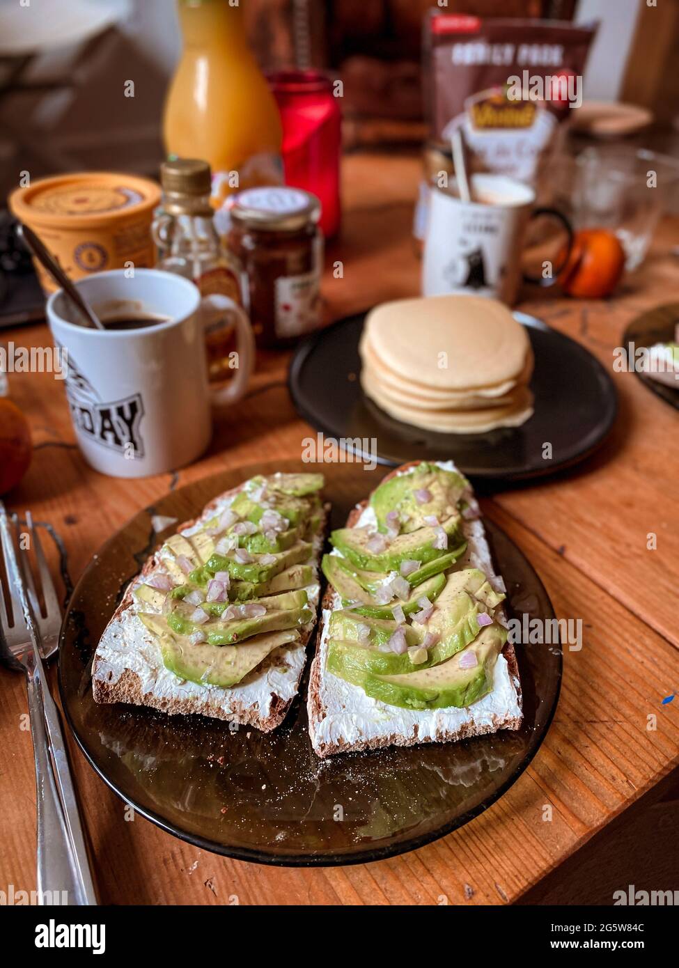 Hausgemachter Brunch mit Avocado-Toast und Pfannkuchen Stockfoto