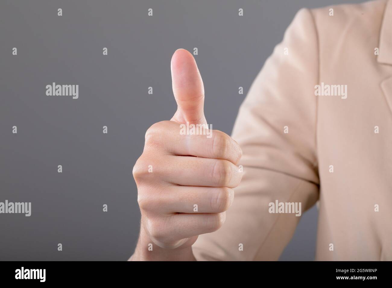 Mittelteil der kaukasischen Geschäftsfrau berührt virtuelle Schnittstelle auf grauem Hintergrund Stockfoto