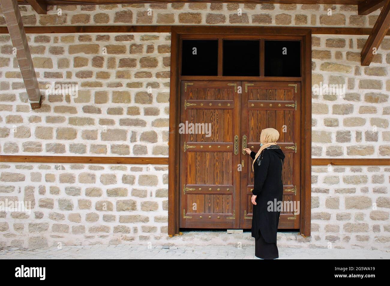 Eine Frau vor einer authentischen anatolischen Haustür Stockfoto