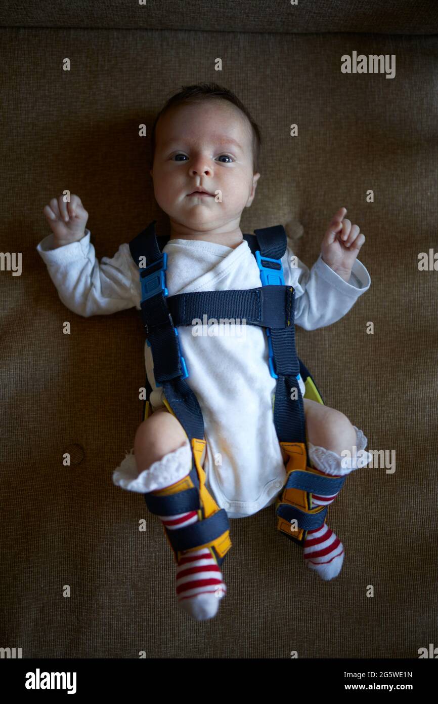 Ein Baby, das ein Geschirr trägt, das Hüftdysplasie korrigiert Stockfoto