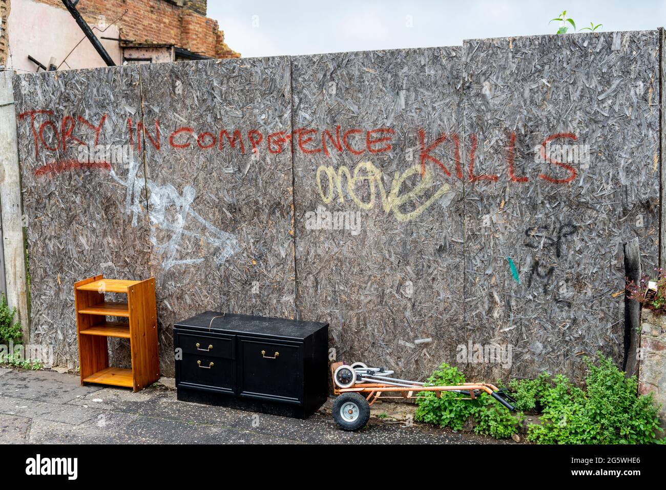 Graffiti auf verfallenden Baustellen mit ausrangierten Objekten in Southend on Sea, Essex, Großbritannien. Graffiti, das besagt, dass Tory Inkompetenz tötet Stockfoto