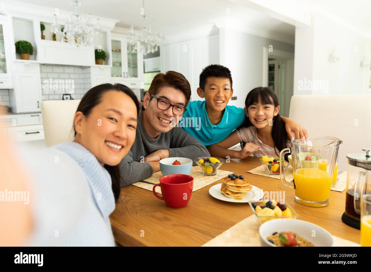 Asiatisches Paar mit Sohn und Tochter, die am Tisch sitzen und zusammen zu Hause essen Stockfoto