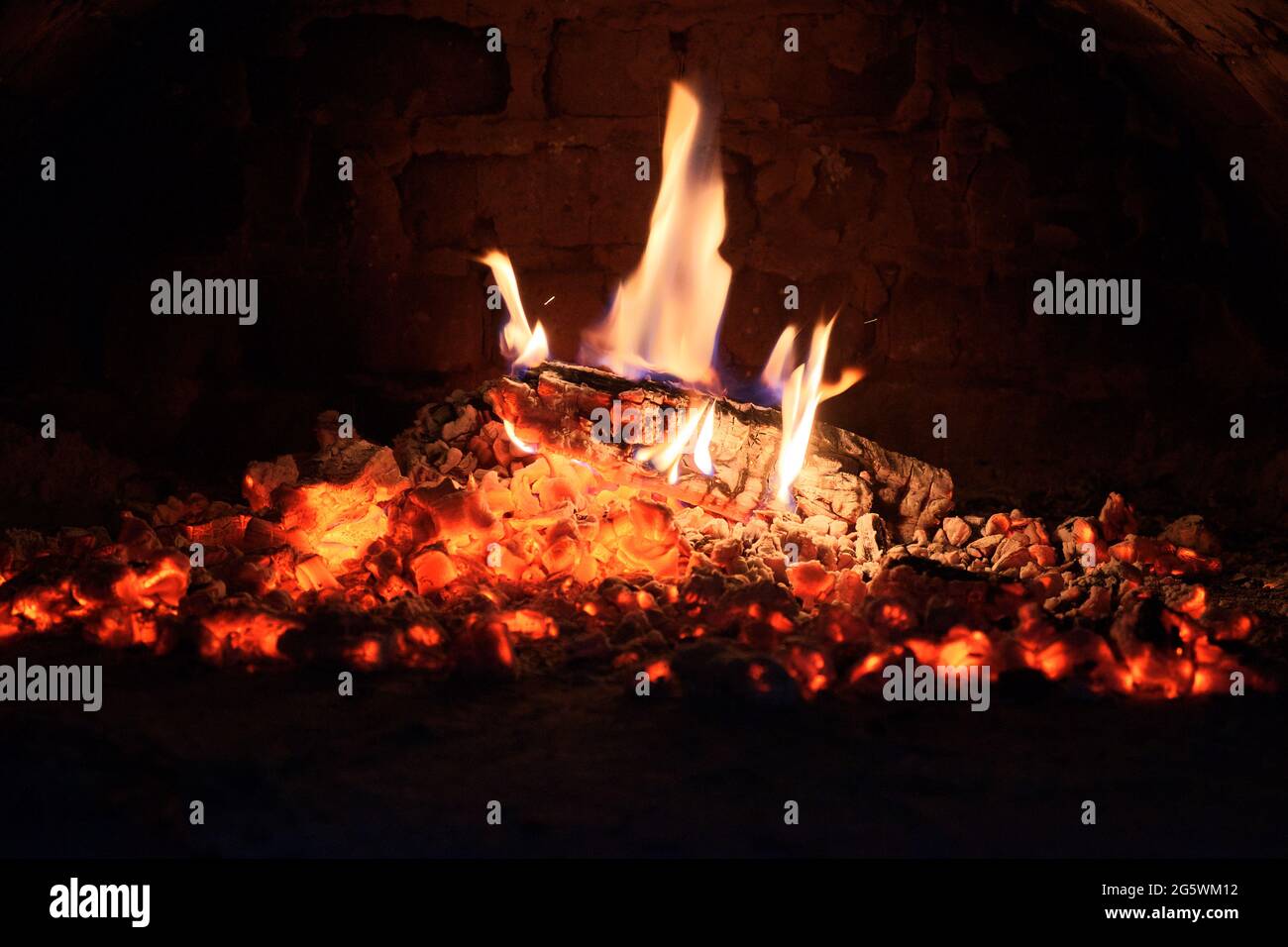 Holzscheite brennen im Ofen aus. Kohlen und Flammen im Kamin. Stockfoto