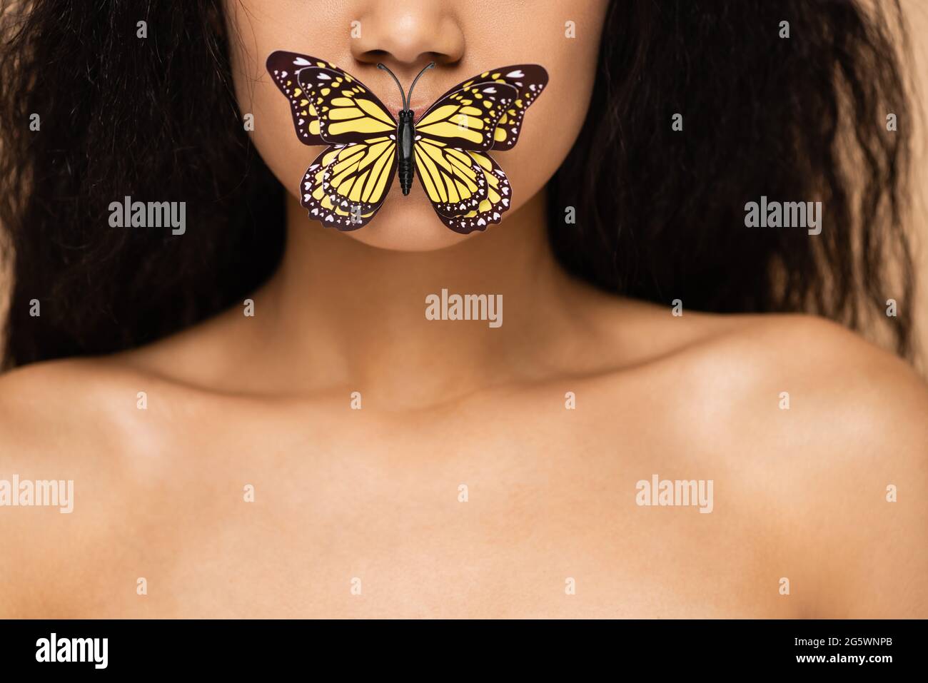 Beschnittene Ansicht der afroamerikanischen jungen Frau mit Schmetterling auf den Lippen Stockfoto