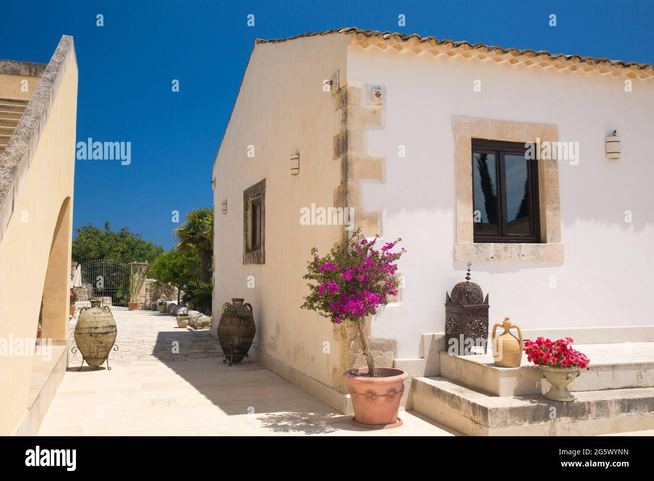 Noto, Syrakus, Sizilien, Italien. Blick auf den sonnendurchfluteten Innenhof des La Corte del Sole, einer ehemaligen masseria aus dem 19. Jahrhundert, die heute ein Boutique-Hotel ist. Stockfoto