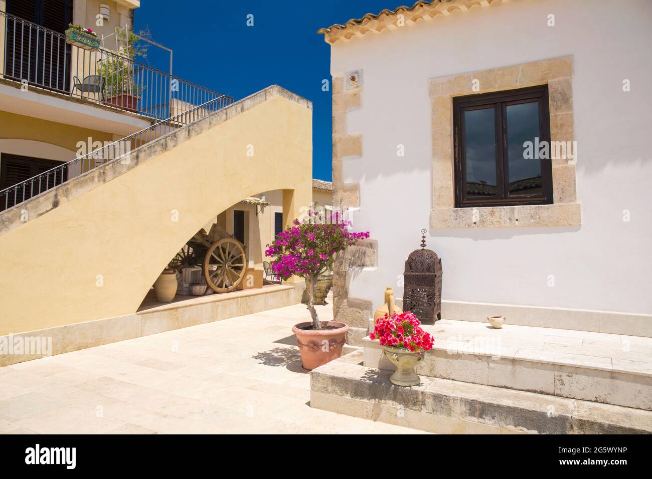 Noto, Syrakus, Sizilien, Italien. Blick auf den sonnendurchfluteten Innenhof des La Corte del Sole, einer ehemaligen masseria aus dem 19. Jahrhundert, die heute ein Boutique-Hotel ist. Stockfoto