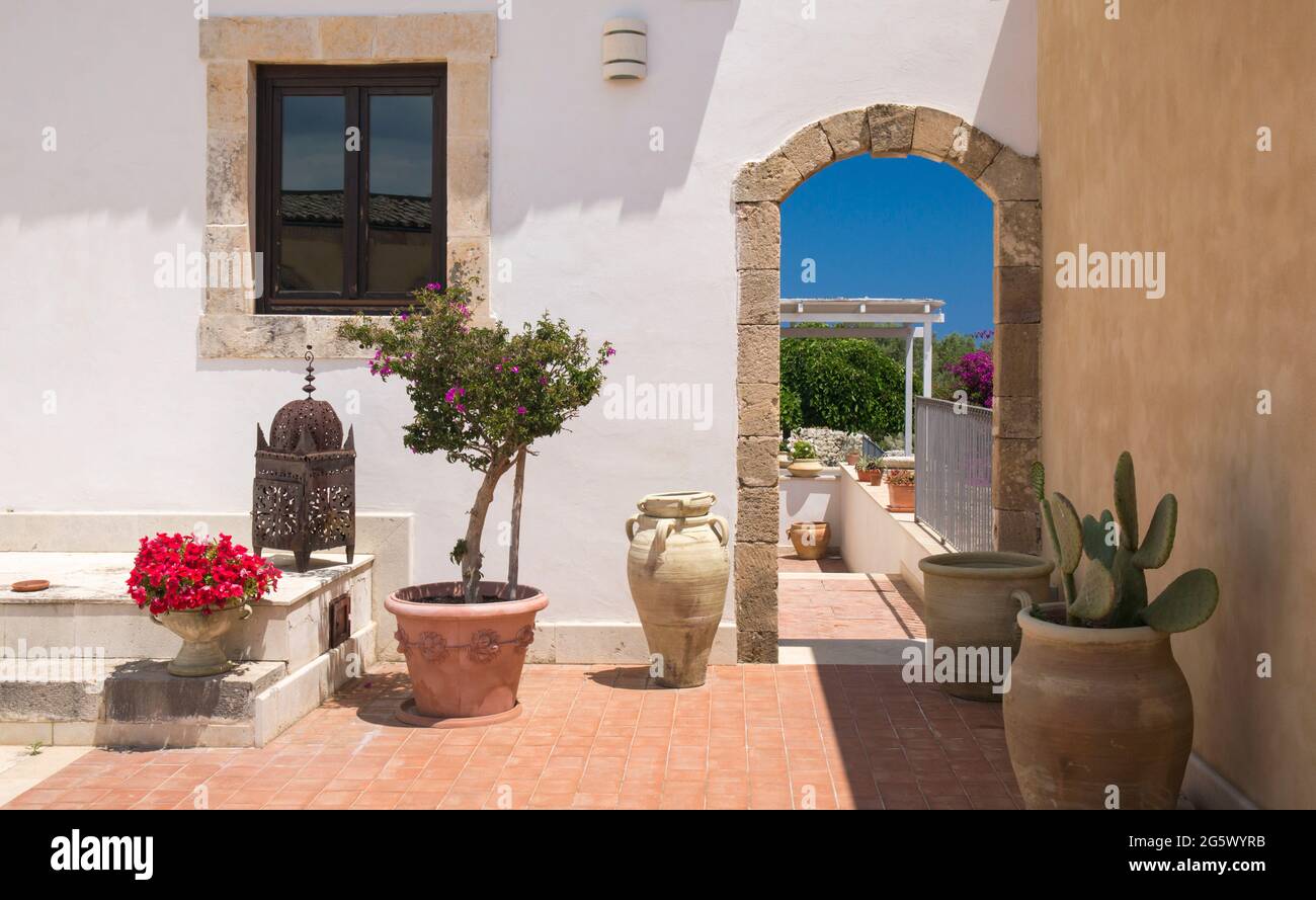 Noto, Syrakus, Sizilien, Italien. Blick auf den sonnendurchfluteten Innenhof des La Corte del Sole, einer ehemaligen masseria aus dem 19. Jahrhundert, die heute ein Boutique-Hotel ist. Stockfoto