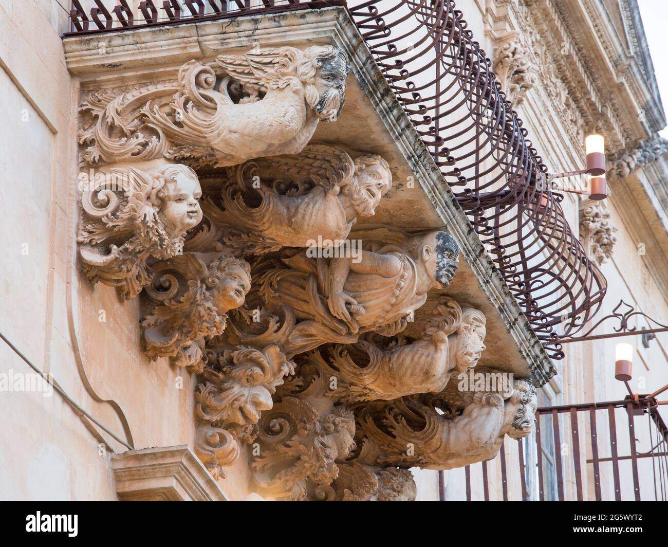 Noto, Syrakus, Sizilien, Italien. Fein geschnitzte Steinfiguren, die einen dekorativen Balkon auf der barocken façade des Palazzo Nicolaci di Villadorata stützen. Stockfoto