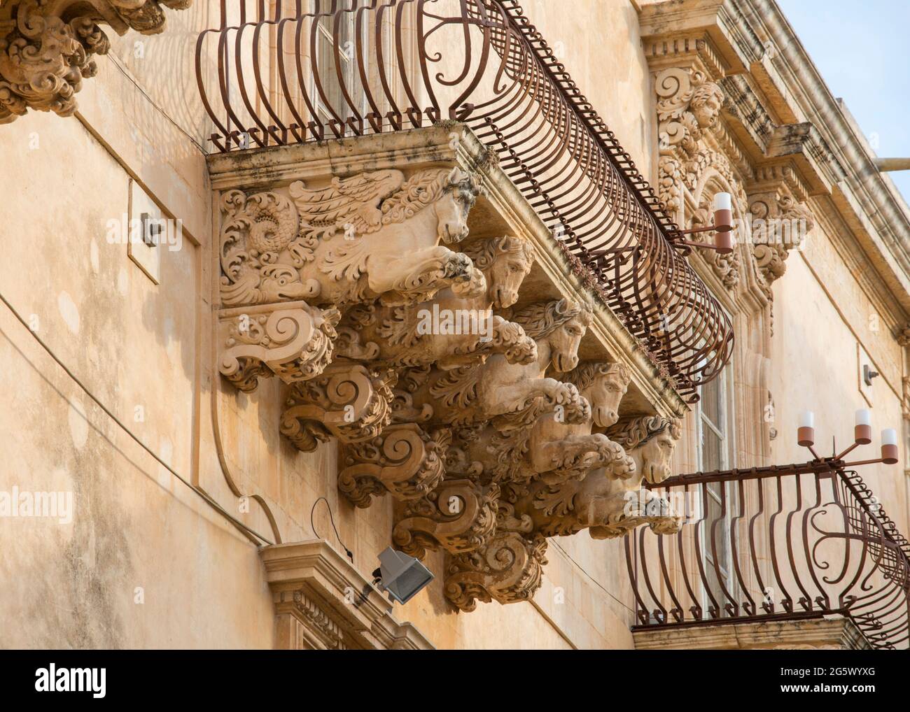 Noto, Syrakus, Sizilien, Italien. Fein geschnitzte Steinfiguren, die einen dekorativen Balkon auf der barocken façade des Palazzo Nicolaci di Villadorata stützen. Stockfoto