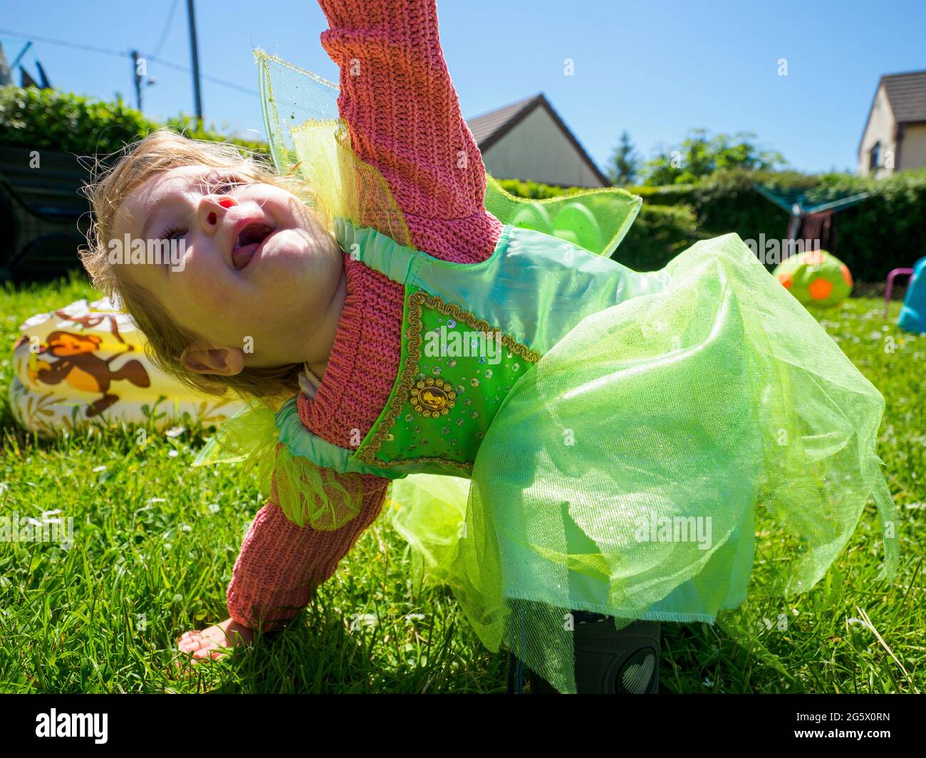 Kleines weibliches Kind, das im Garten spielt, Cornwall, Großbritannien Stockfoto