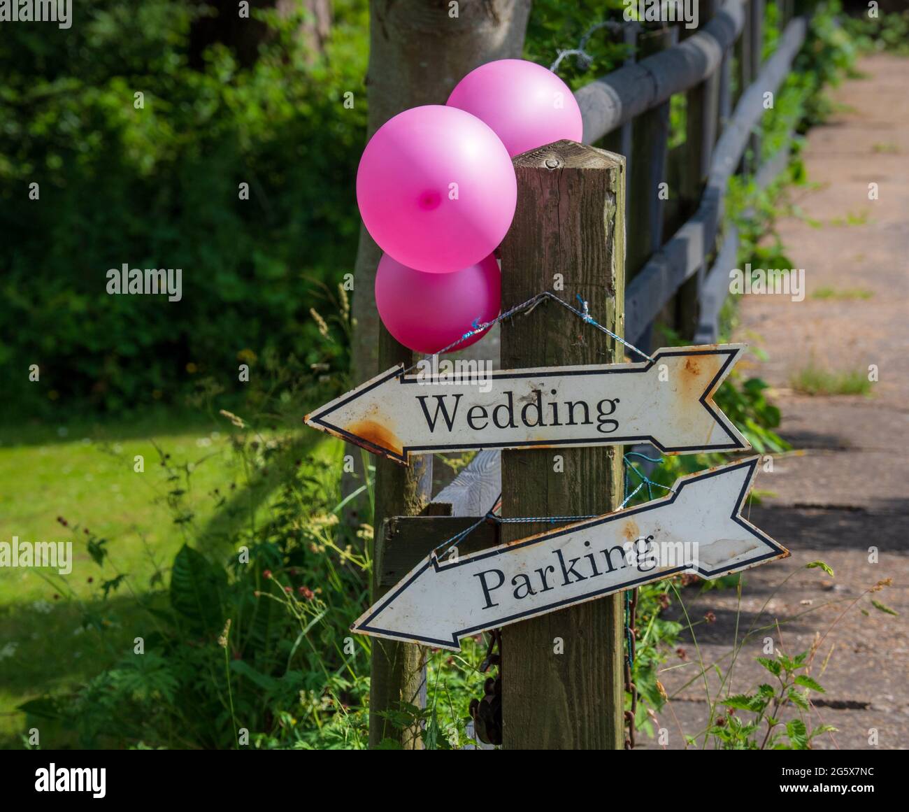 Hochzeitsschilder für das Parken mit feierlichen rosa Ballons an einem sonnigen Sommertag auf dem Land Stockfoto