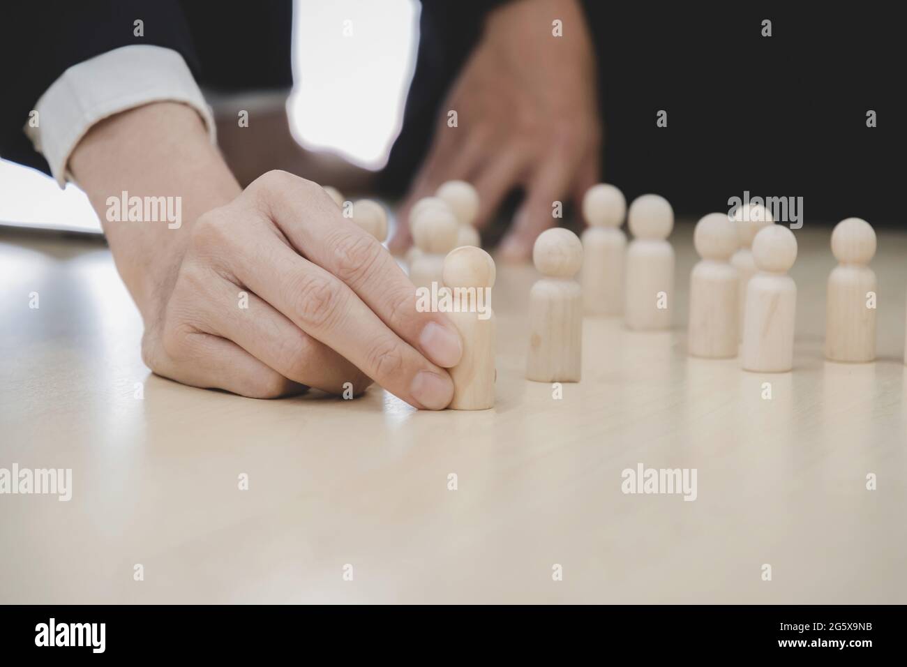 Personalwesen. Geschäftsleute, die sich für einen hölzernen Leiter aus der Menge der Mitarbeiter am Schreibtisch, Teamleiter, Personalmanager, Unternehmensführung, Stockfoto